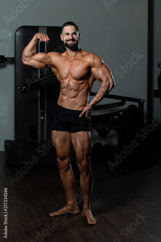 Handsome Muscular Man Flexing Muscles In Gym