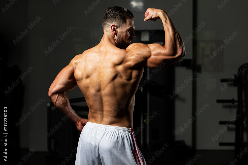 Biceps Pose Of A Young Man In Gym Biceps Pose Of A Young Man In Gym