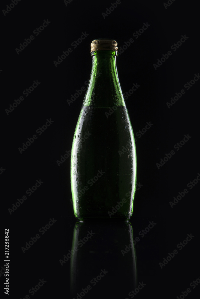 green soda bottle on the black green soda bottle on the black