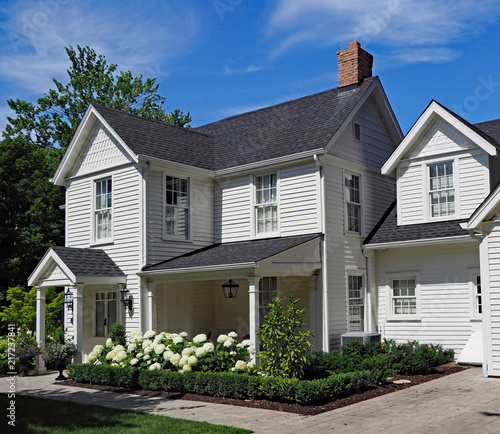 Photo white clapboard house with gable and portico entrance