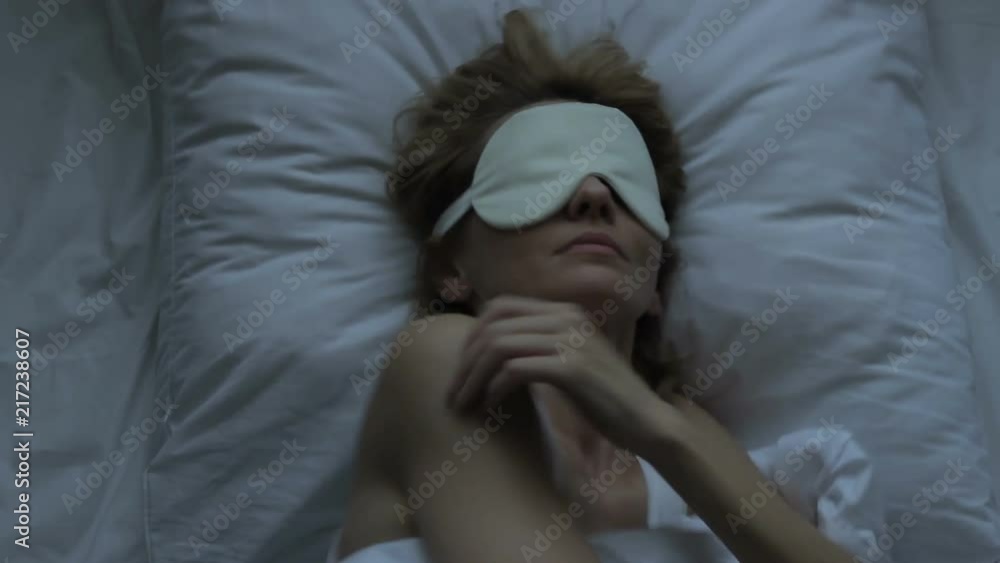 Alarmed woman sleeping uncomfortably having problems sweating horrible nightmare Alarmed woman sleeping uncomfortably having problems sweating horrible nightmare