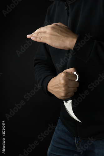 Crime and violence concept, a murderer with a karambit knife trying to kill victim