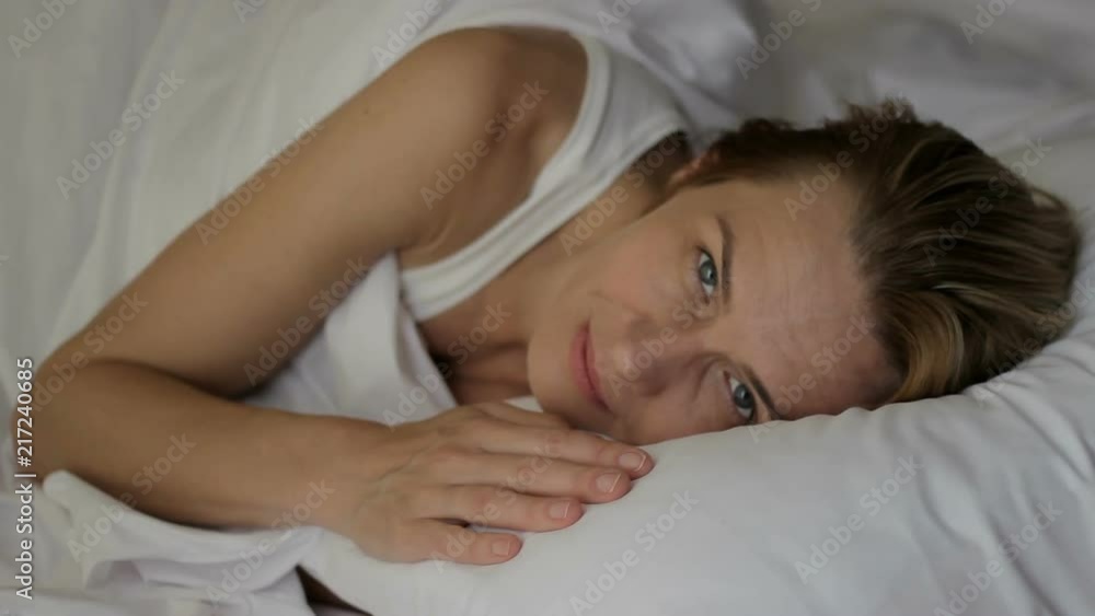 Middle-aged attractive woman smiling pleasant sleep, blue eyes looking at camera Middle-aged attractive woman smiling pleasant sleep, blue eyes looking at camera