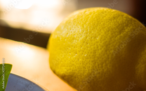 lemon with water drops close-up backgroundTransparent small water drops of perspiration on the skin of a large lemon on a hot day photo