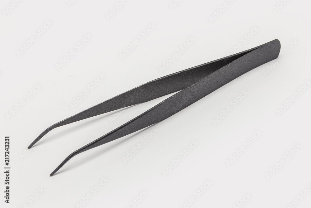 titanium tweezers(pincette) on the white background. titanium tweezers(pincette) on the white background.