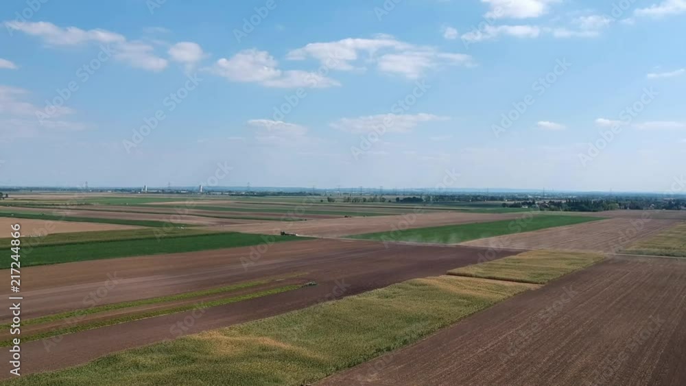 Farmer plowing his field with industrial tractor kicking up dust AERIAL. Farmer plowing his field with industrial tractor kicking up dust AERIAL.