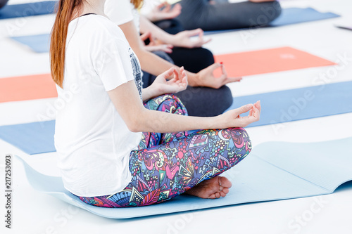 Close-up detail of Young woman meditating and practicing yoga at class or seminar