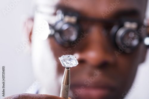 Person Looking At Diamond With Magnifying Loupe