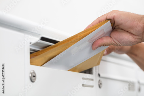 Man taking letters from mailbox
