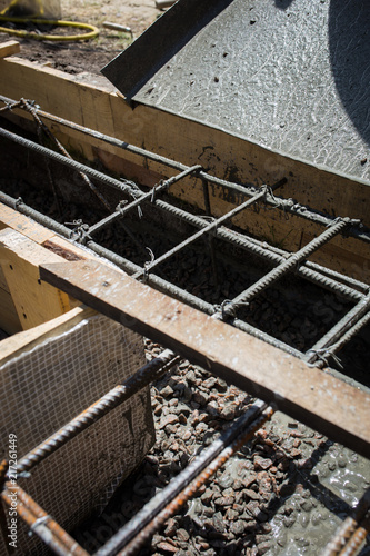 Close up wire mesh and wet cement in concrete floor pouring process