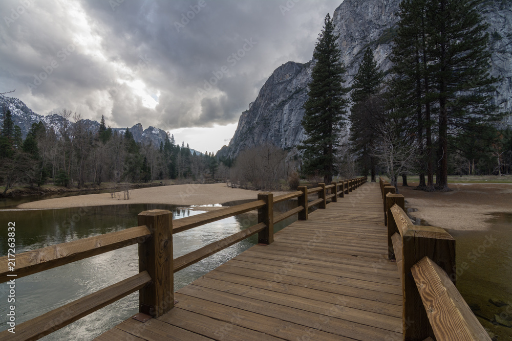 Obraz premium Wooden pathway on pond among mountains