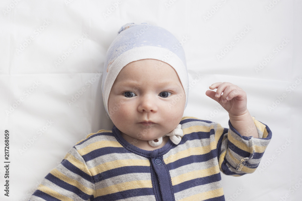 Portrait of a little baby in clothes with a funny expression fac Portrait of a little baby in clothes with a funny expression fac