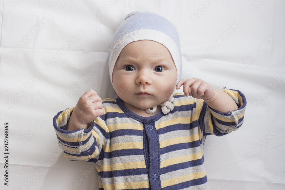Portrait of a little baby in clothes with a funny expression fac Portrait of a little baby in clothes with a funny expression fac