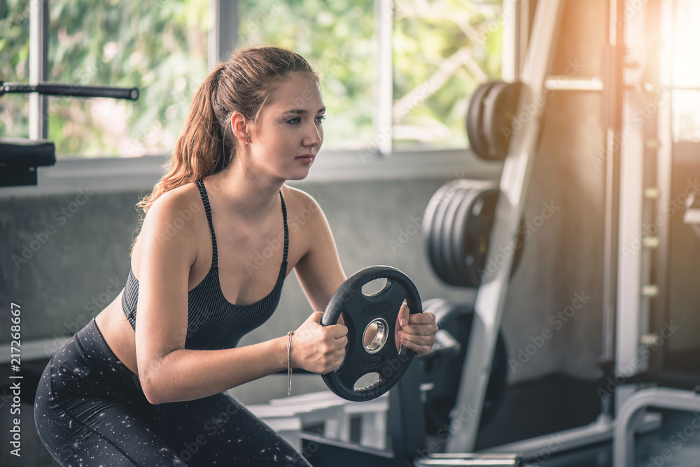 Fototapeta premium Cinematic tone of young attractive fitness woman exercise with machine in gym. 