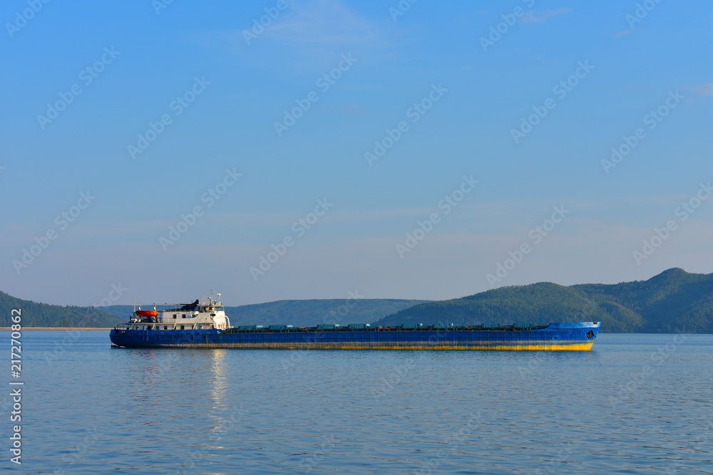 Cargo ship on the background of mountains.