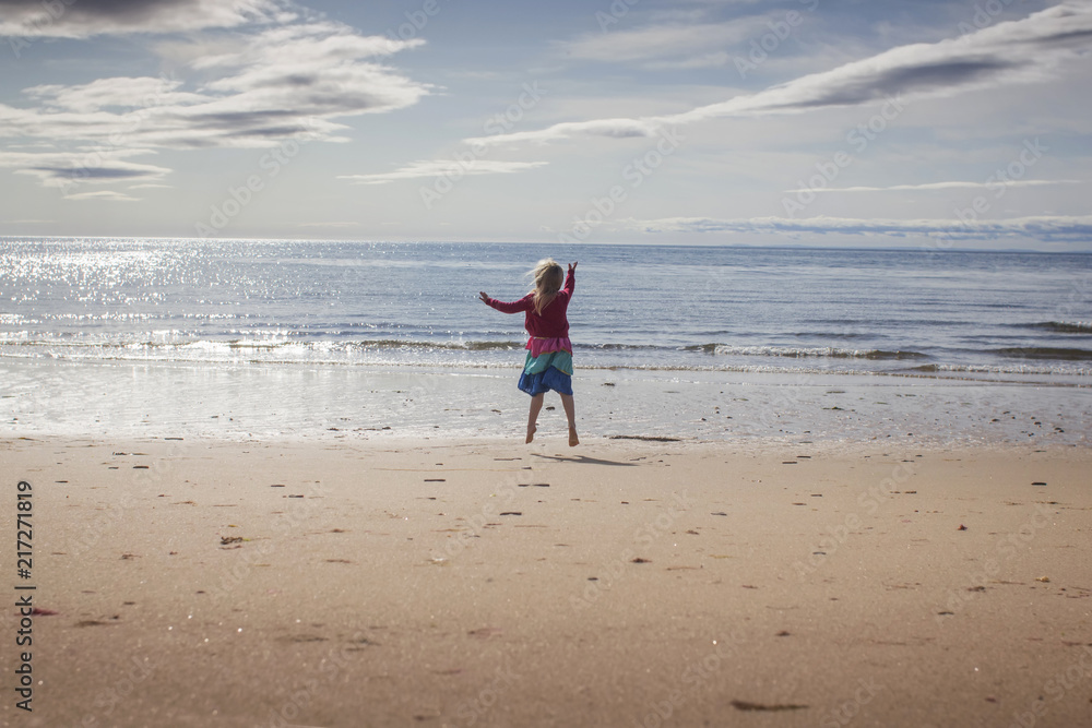 Young girl leap for joy on a beach Young girl leap for joy on a beach
