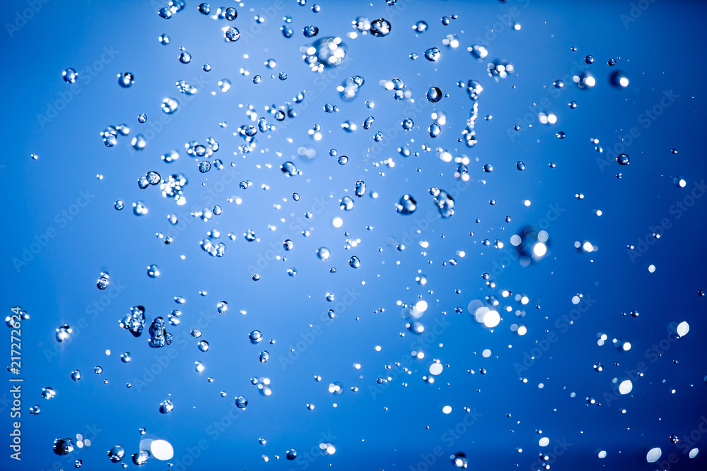 Close up of a water drops on a blue gradient background, covered with drops of water -condensation. Close-up of a drop of a fountain flying upward Close up of a water drops on a blue gradient background, covered with drops of water -condensation. Close-up of a drop of a fountain flying upward