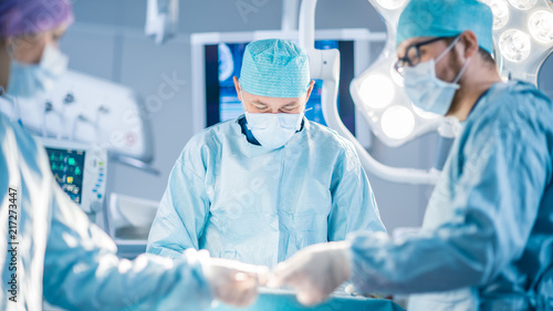 Shot in the Operating Room, Assistant Hands out Instruments to Surgeons During Operation. Surgeons Perform Operation. Professional Medical Doctors Performing Surgery.