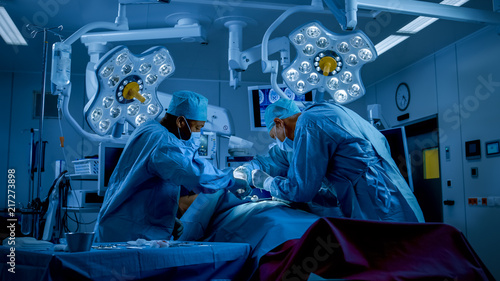 Valokuva Diverse Team of Professional Surgeons Performing Invasive Surgery on a Patient in the Hospital Operating Room
