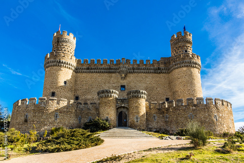 Facade of a medieval castle palace under a blue sky (Manzanares el Real, Spain) photo