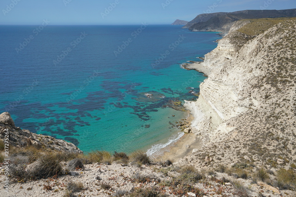 Coastal sandstone cliff and clear water of the Mediterranean sea near Agua Amarga, Cabo de Gata-Nijar Natural Park, Almeria, Andalusia, Spain