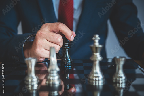 hand of businessman moving chess figure in competition success play. strategy, management or leadership concept 