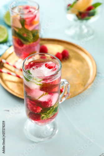 Glass of fresh raspberry mojito on light table