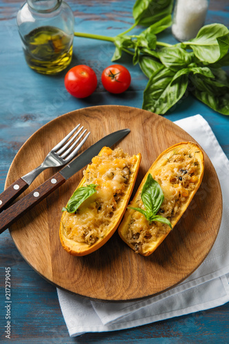 Plate with quinoa stuffed zucchini boats on wooden table