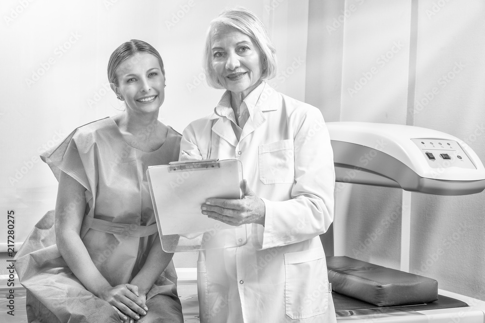 Φωτογραφία Woman discussing scan test at hospital with her female doctor, sun rays coming f