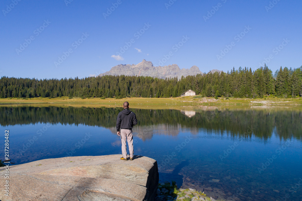 Hiker looks at alpine lake