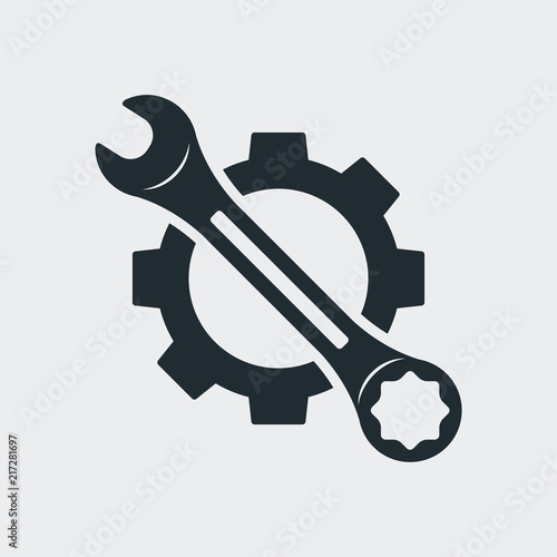Icono plano engranaje con llave en diagonal en fondo gris