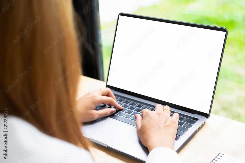 Woman using mockup laptop computer with white screen display. Woman using mockup laptop computer with white screen display.