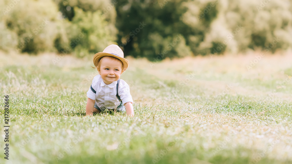 stylish toddler in straw hat crawling on field stylish toddler in straw hat crawling on field