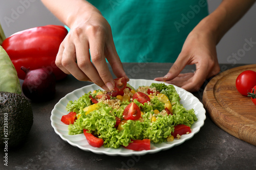 Fototapeta Naklejka Na Ścianę i Meble -  Woman preparing healthy salad on grey table, closeup