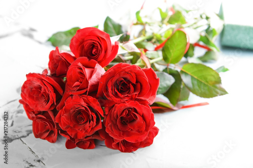 Beautiful bouquet of red roses on table