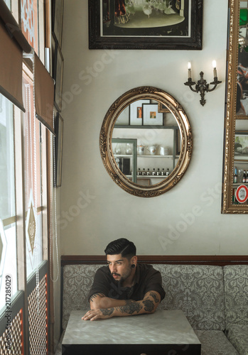 Vintage men tattooing and posing in a retro bar