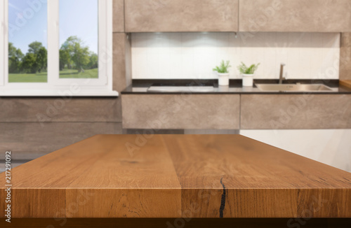 Kitchen, background. Empty textured wooden table and kitchen window shelves blurred background