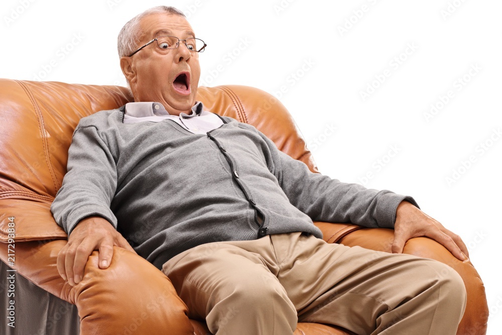 Obraz premium Terrified mature man sitting in an armchair