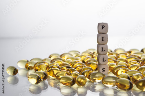 Word pills from the letters of cubes and Lecithin gel pills on light background. photo