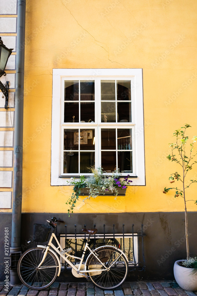 urban scene with bicycle parked near bright yellow building wall in Riga, Latvia urban scene with bicycle parked near bright yellow building wall in Riga, Latvia