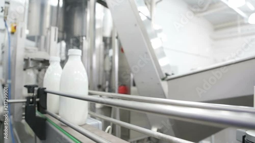 Avtomaticheskaya production line of dairy products. Milk bottles move along the conveyor. photo