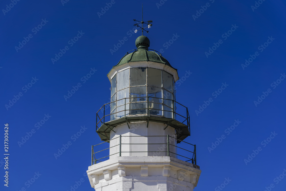 Deserted lighthouse against blue background. Day view of lighthouse Armenistis manufactured in 1891 on the north-western tip of Mykonos, Greece.