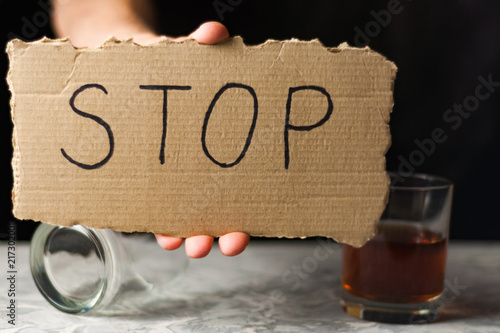 Obraz na plátně Man holds worn rectangle cardboard with handwritten inscription stop near transp