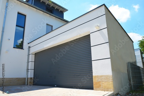 Moderne Beton-Garage mit Automatik-Tor in der Hauszufahrt