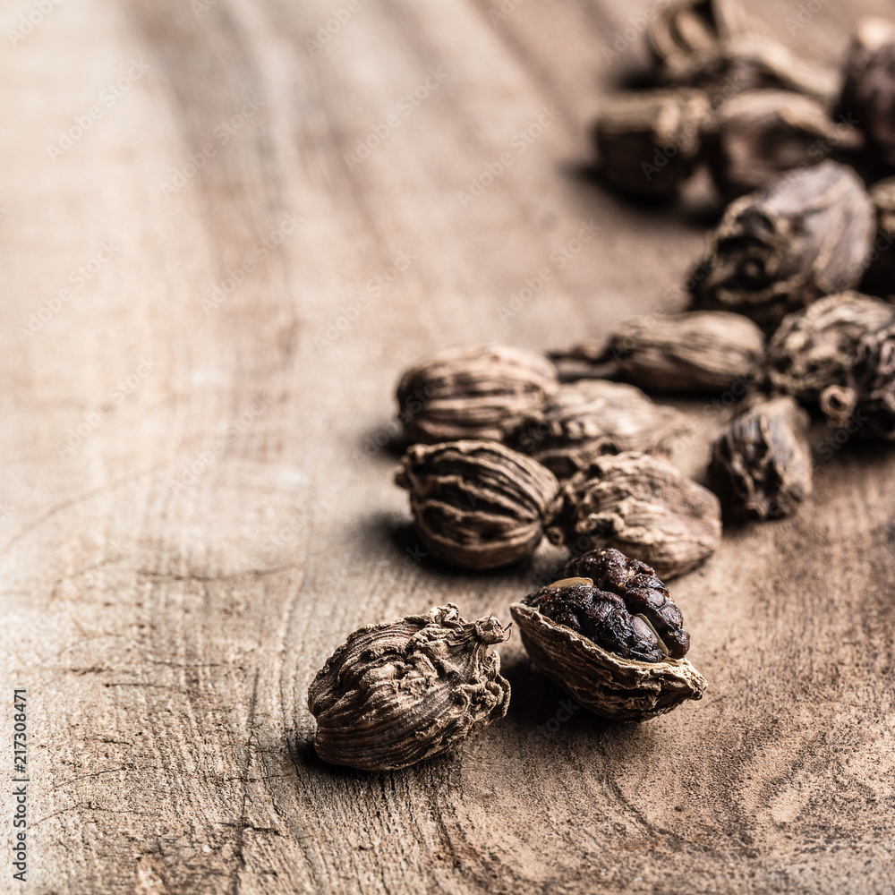 Black cardamom scattered on wooden background with copy space. Black cardamom scattered on wooden background with copy space.