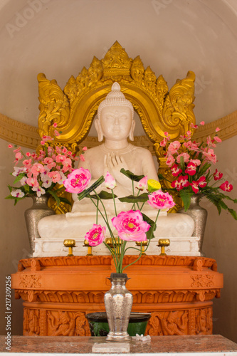 White buddha statue with gold decoration at the back