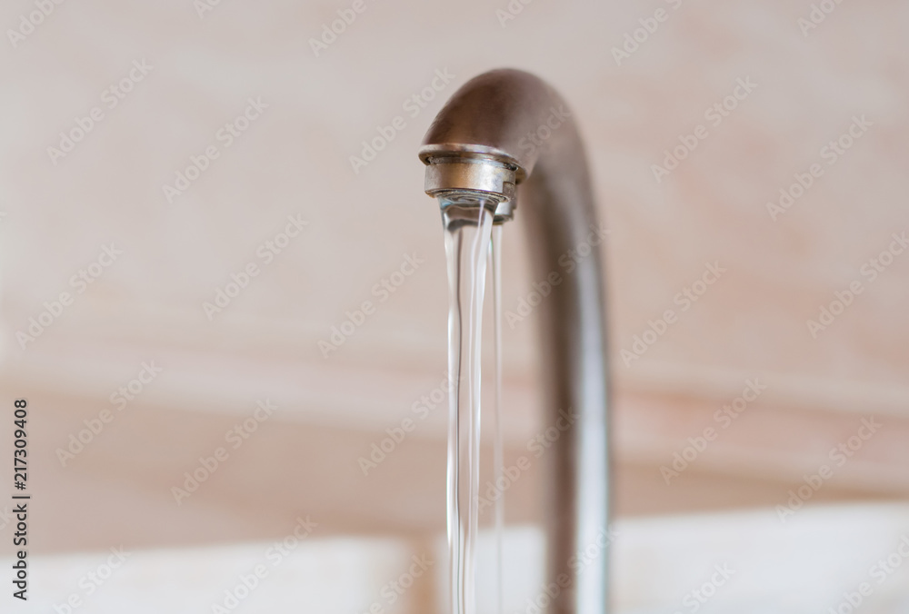 Water frowing faucet. Water running from the kitchen tap. Concept of water consumption Water frowing faucet. Water running from the kitchen tap. Concept of water consumption