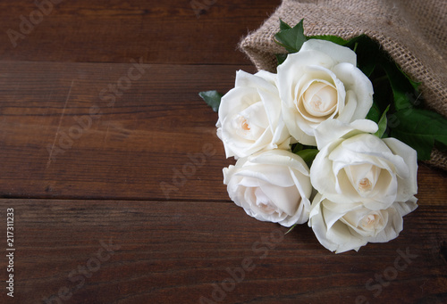 Bunch of beautiful white roses on wooden background © taaree