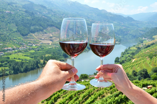 Wine glasses against vineyards in Douro Valley, Portugal
