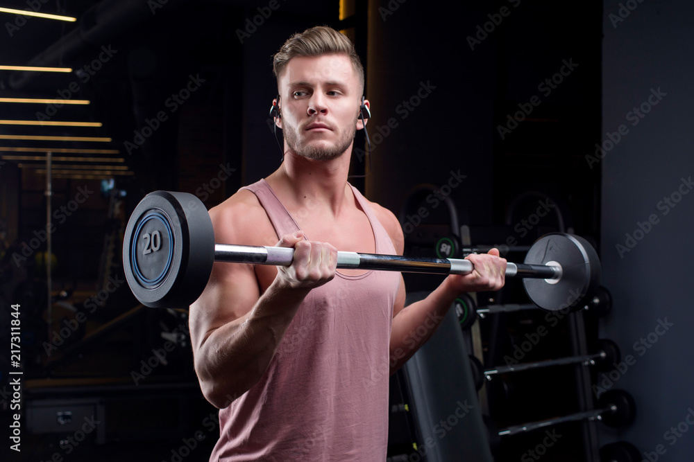 Guy bodybuilder in the gym shakes muscles. Top view, copy space Guy bodybuilder in the gym shakes muscles. Top view, copy space
